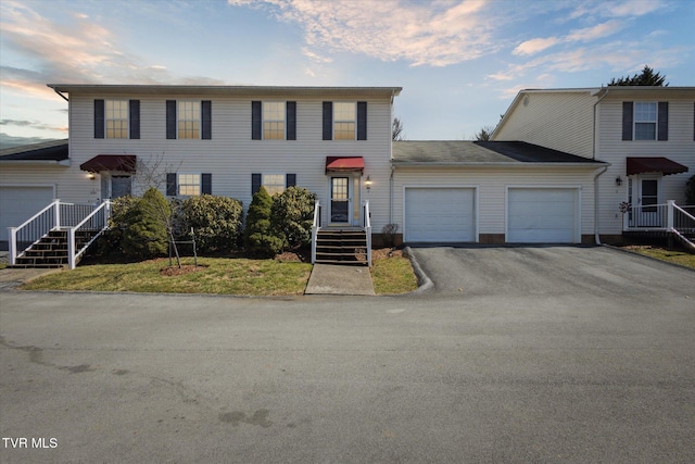 colonial home featuring a garage and aphalt driveway