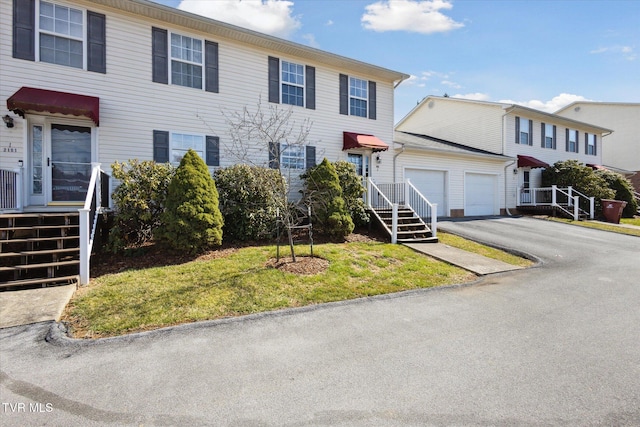 view of front of house featuring an outdoor structure, an attached garage, and driveway