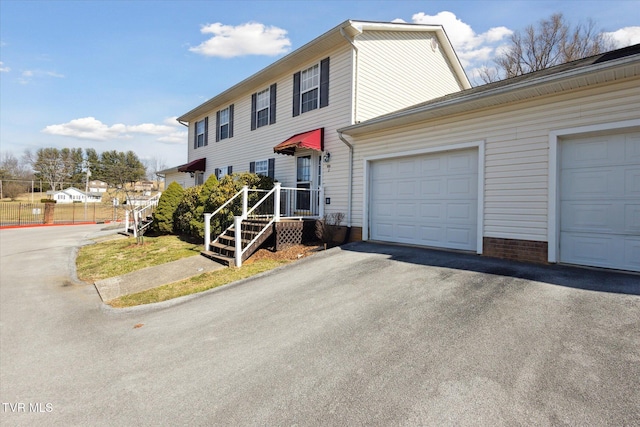 colonial inspired home with aphalt driveway and a garage