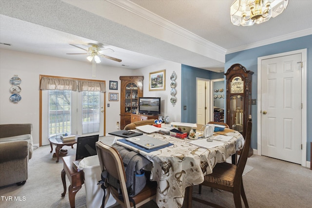 dining room with a textured ceiling, light colored carpet, ornamental molding, and ceiling fan with notable chandelier