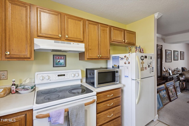 kitchen with white appliances, brown cabinetry, under cabinet range hood, and light countertops