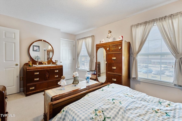 bedroom with multiple windows, carpet floors, and a textured ceiling