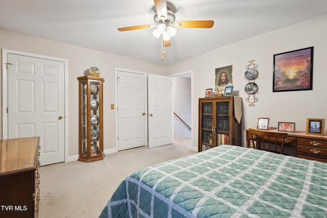 bedroom with baseboards, light carpet, a textured ceiling, and a ceiling fan