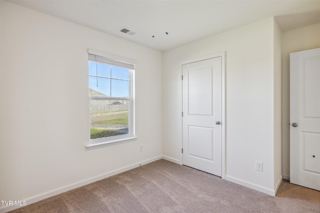 unfurnished bedroom featuring visible vents, baseboards, and carpet