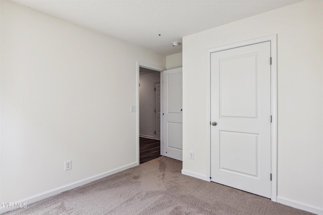 unfurnished bedroom with carpet flooring and baseboards