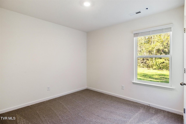 carpeted empty room featuring visible vents, baseboards, and a healthy amount of sunlight