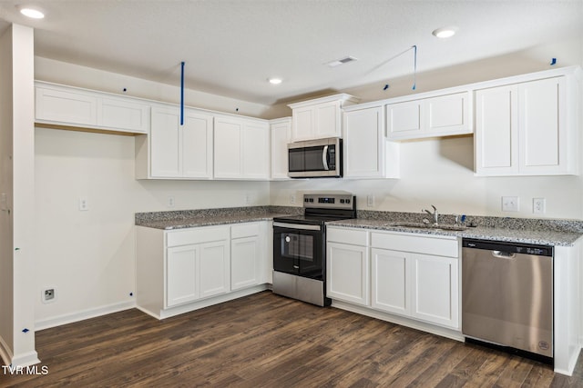 kitchen featuring dark wood-style flooring, white cabinets, stainless steel appliances, and a sink