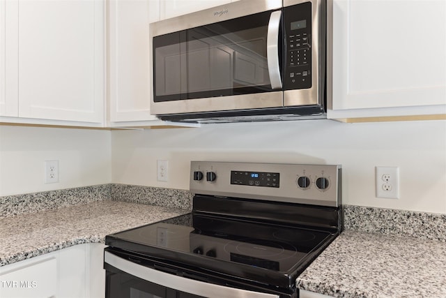 kitchen featuring white cabinetry, light stone countertops, and stainless steel appliances