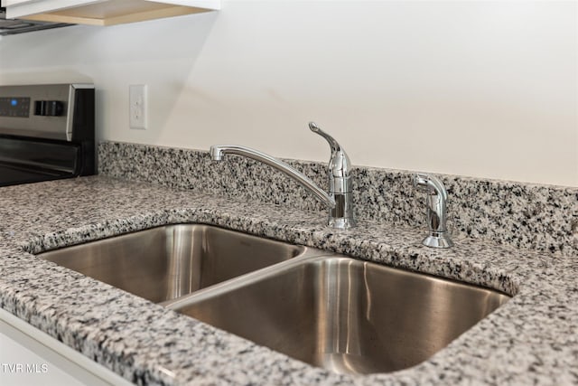 room details featuring light stone countertops and a sink