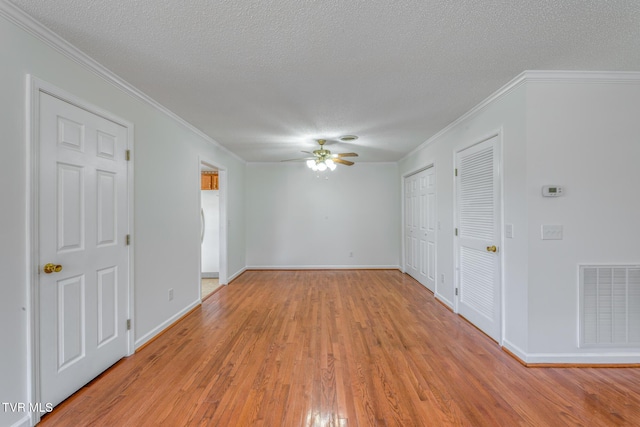 spare room with visible vents, crown molding, ceiling fan, light wood-type flooring, and a textured ceiling