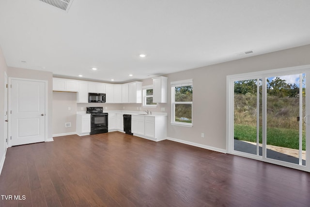 kitchen with recessed lighting, dark wood-style flooring, a sink, black appliances, and light countertops