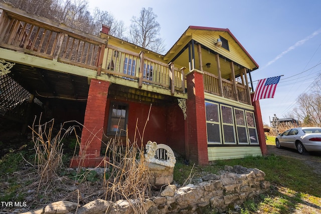 view of side of property with a chimney and a deck