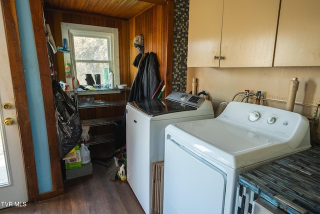 washroom featuring washer and clothes dryer, wooden ceiling, dark wood-type flooring, wooden walls, and cabinet space