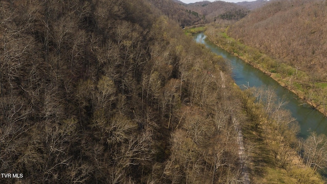 drone / aerial view with a wooded view and a water and mountain view