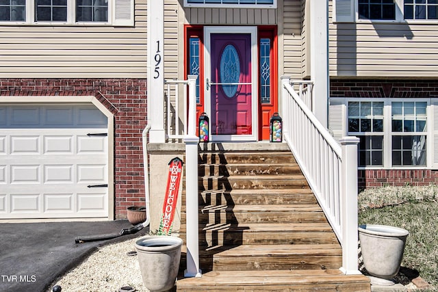 entrance to property featuring brick siding and a garage