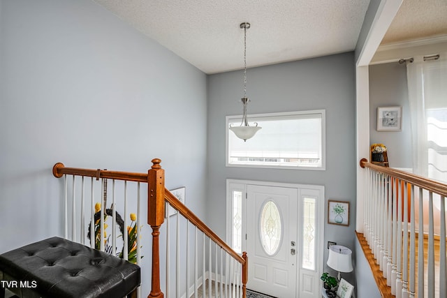 entrance foyer featuring a towering ceiling and a textured ceiling