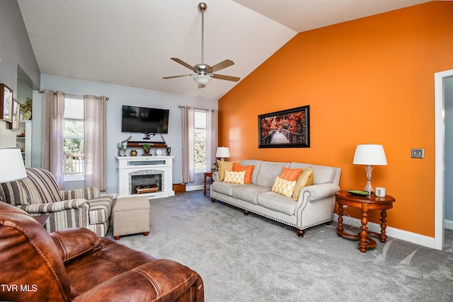 living room with lofted ceiling, a fireplace with raised hearth, a ceiling fan, carpet, and baseboards