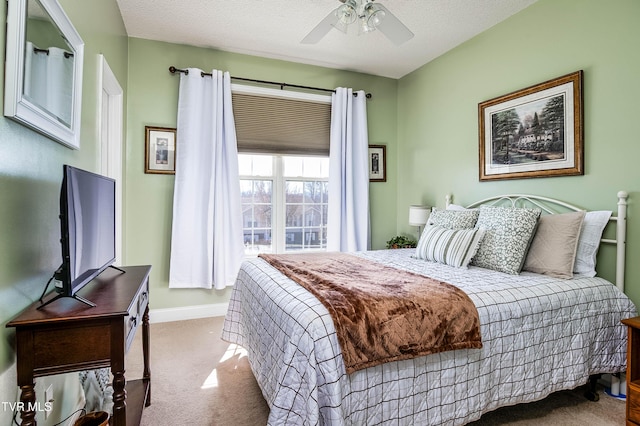 carpeted bedroom featuring ceiling fan, a textured ceiling, and baseboards