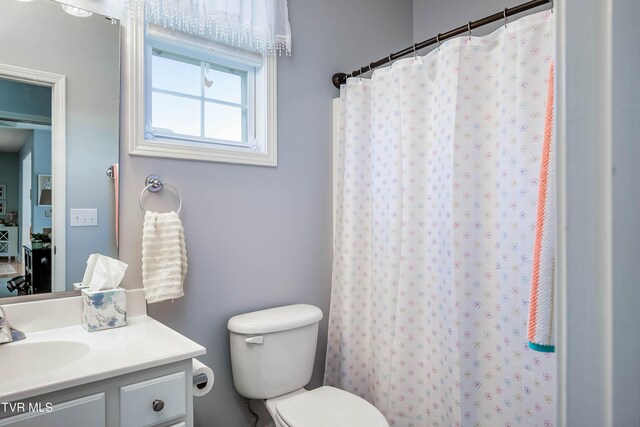 full bath featuring curtained shower, toilet, and vanity