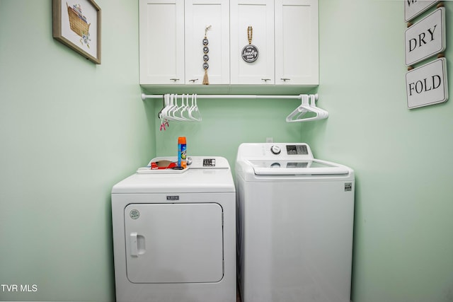 laundry room featuring separate washer and dryer and cabinet space