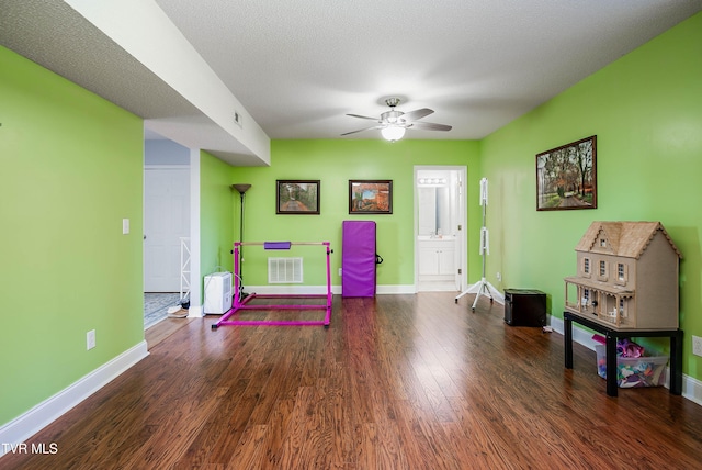 game room with visible vents, ceiling fan, baseboards, and wood finished floors