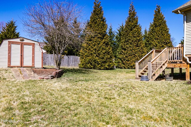 view of yard with stairs, an outdoor structure, fence, and a shed