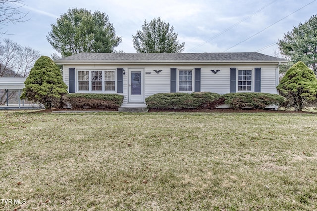 ranch-style home with roof with shingles and a front lawn