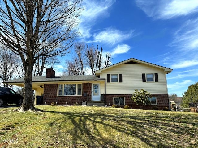 tri-level home featuring brick siding, a chimney, a front lawn, and fence