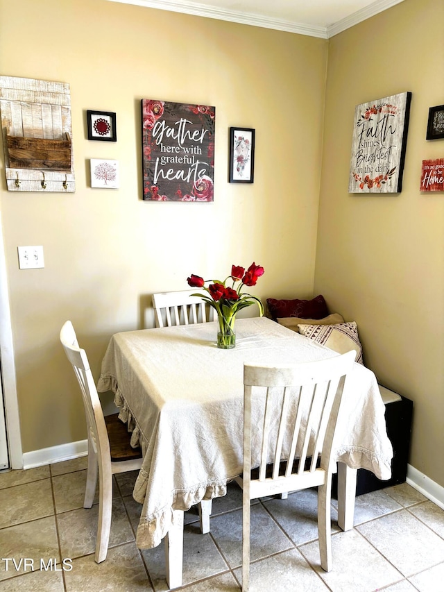 dining room with baseboards, crown molding, and tile patterned flooring