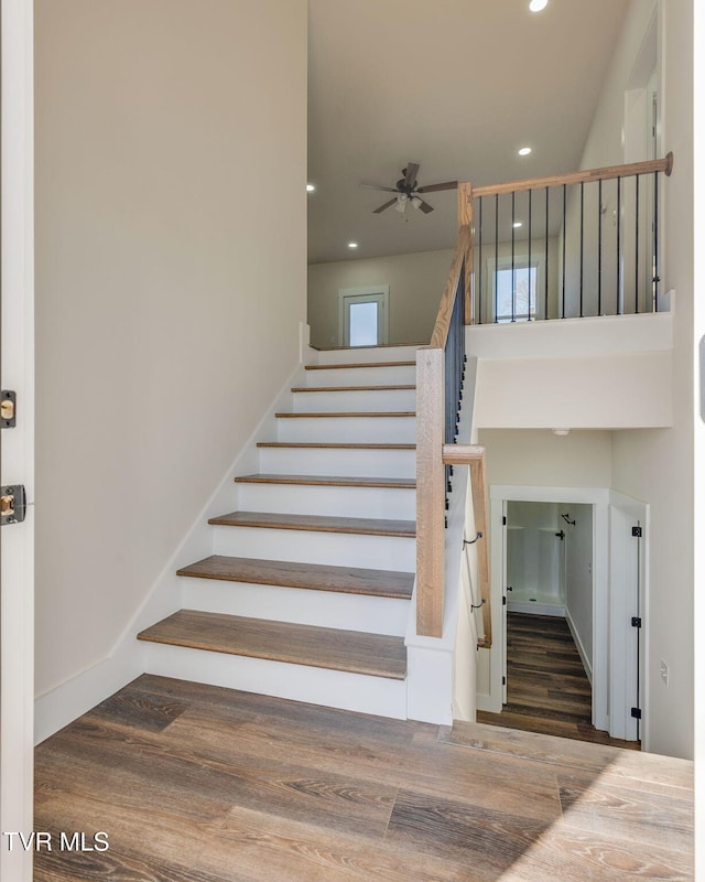 stairs with a ceiling fan, recessed lighting, wood finished floors, and baseboards