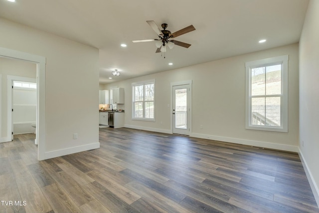 unfurnished living room featuring recessed lighting, baseboards, and wood finished floors