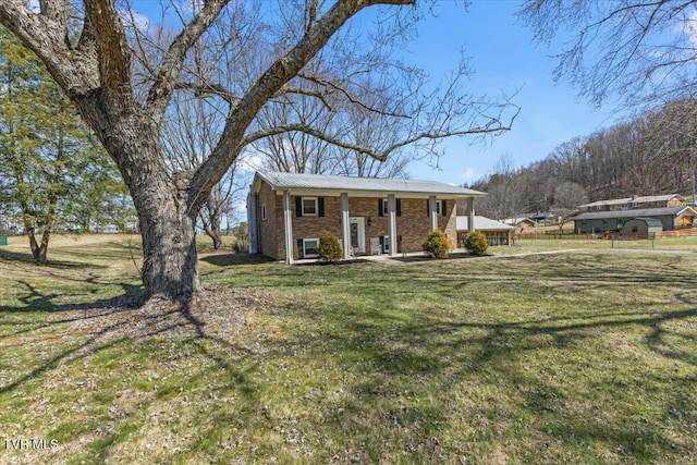 view of front of property featuring brick siding, a porch, and a front lawn