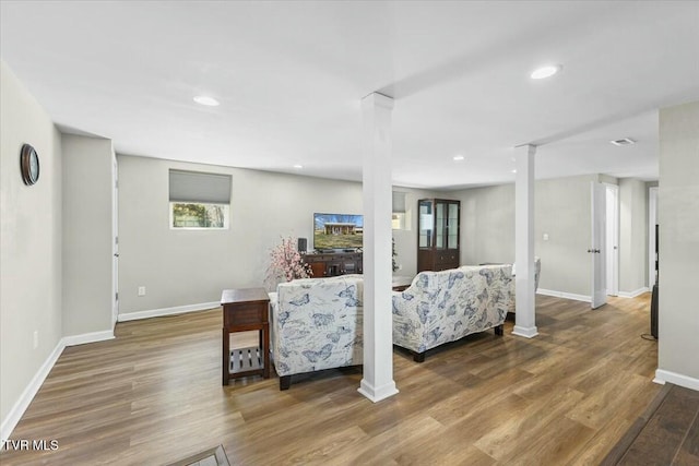 living room featuring recessed lighting, decorative columns, baseboards, and wood finished floors