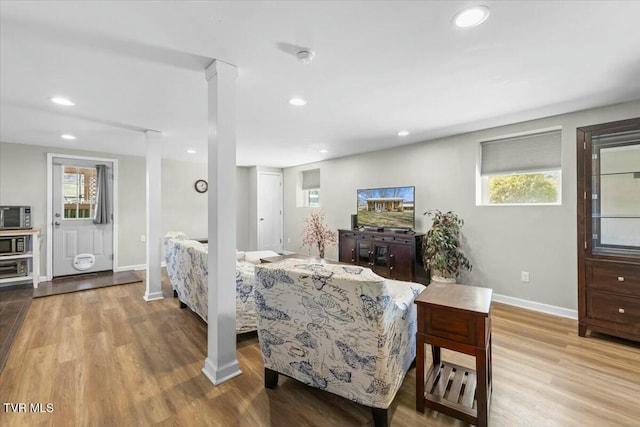 living room with recessed lighting, decorative columns, baseboards, and wood finished floors