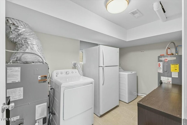 laundry room with visible vents, independent washer and dryer, laundry area, and water heater