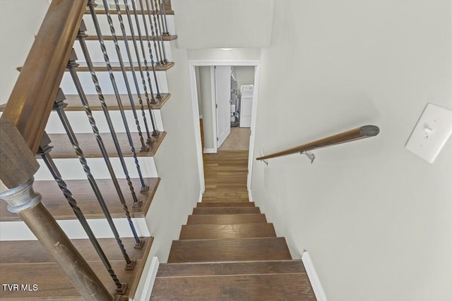 stairway with washer / clothes dryer and wood finished floors