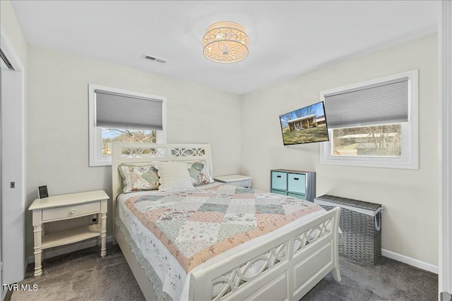 bedroom featuring visible vents, multiple windows, and dark carpet