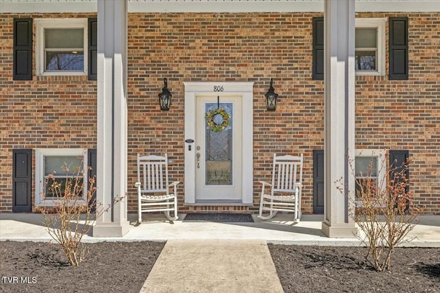 doorway to property featuring brick siding