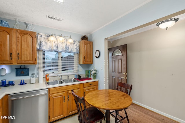 kitchen featuring visible vents, a sink, light countertops, light wood-style floors, and dishwasher