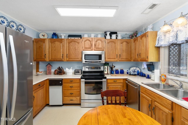 kitchen with a sink, visible vents, appliances with stainless steel finishes, and light countertops