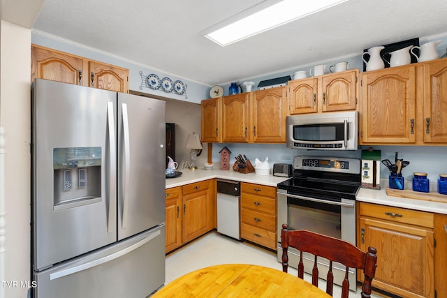 kitchen featuring brown cabinetry, appliances with stainless steel finishes, and light countertops