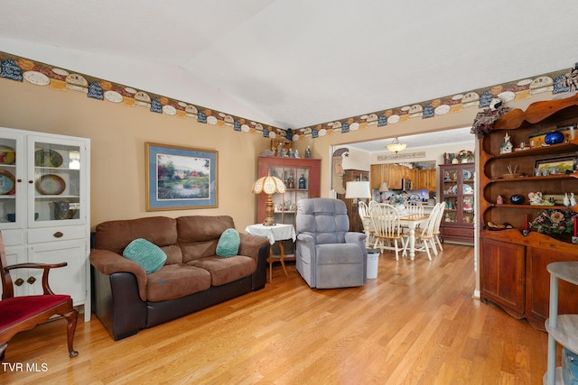 living area featuring lofted ceiling and light wood-style floors