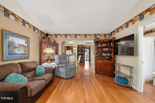 living room featuring light wood-style flooring and lofted ceiling