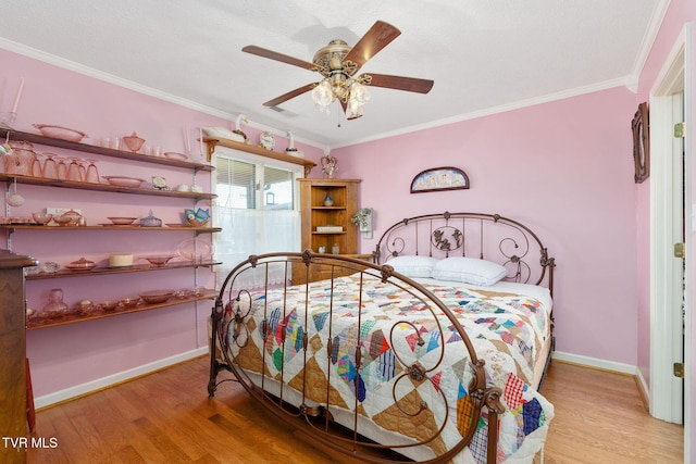 bedroom with baseboards, crown molding, and light wood-style floors