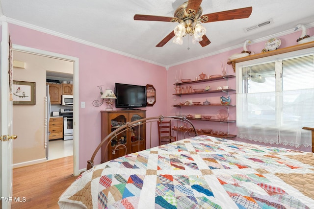 bedroom featuring baseboards, visible vents, light wood-style flooring, ceiling fan, and crown molding