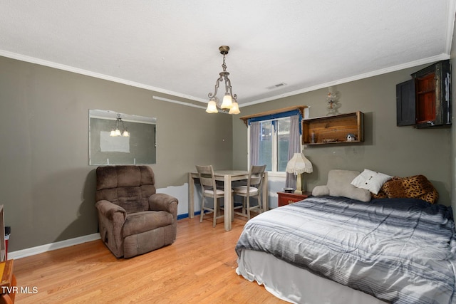 bedroom featuring light wood-type flooring, visible vents, an inviting chandelier, crown molding, and baseboards