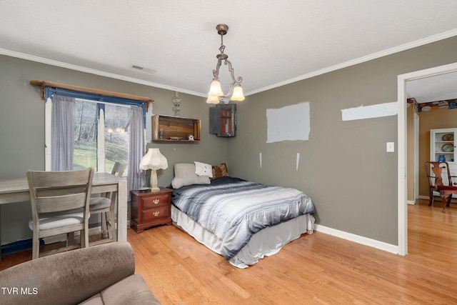 bedroom with visible vents, baseboards, wood finished floors, and crown molding