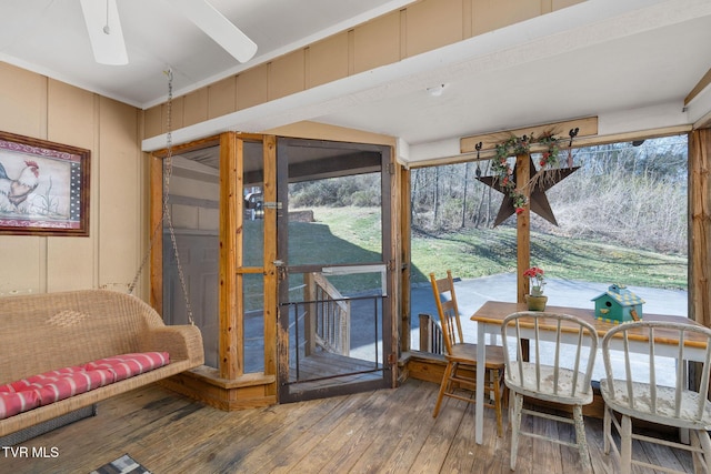 interior space featuring hardwood / wood-style floors, a decorative wall, and a ceiling fan