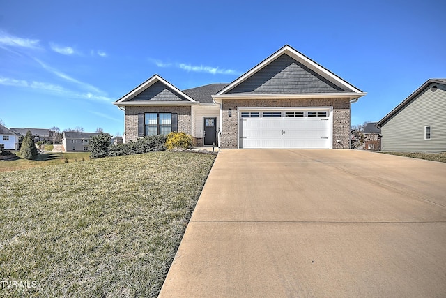 view of front of property with a front yard, brick siding, an attached garage, and driveway