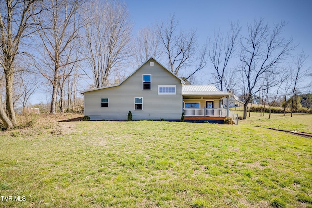 back of house featuring a yard, covered porch, and metal roof